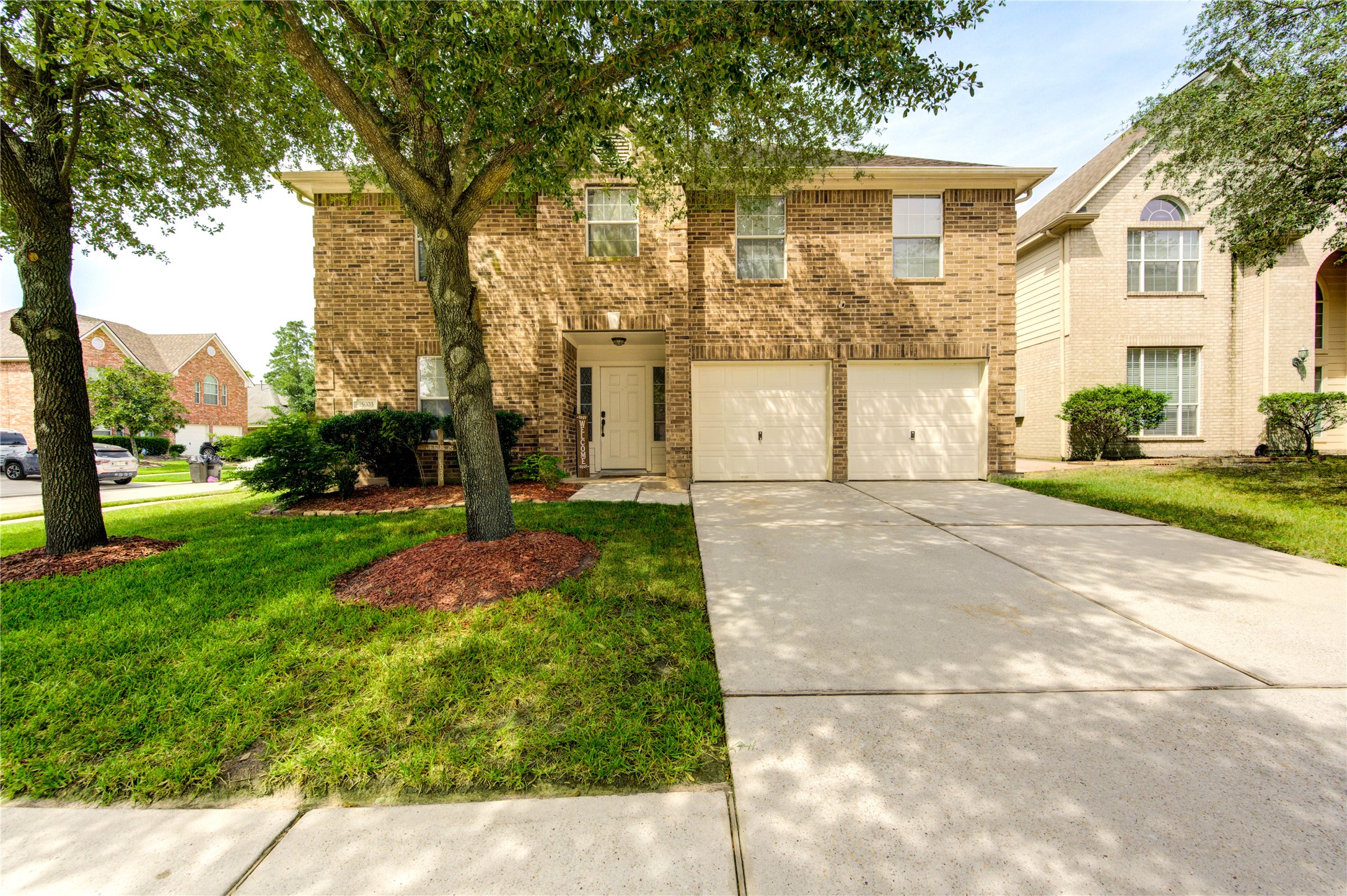 a front view of a house with a yard and trees