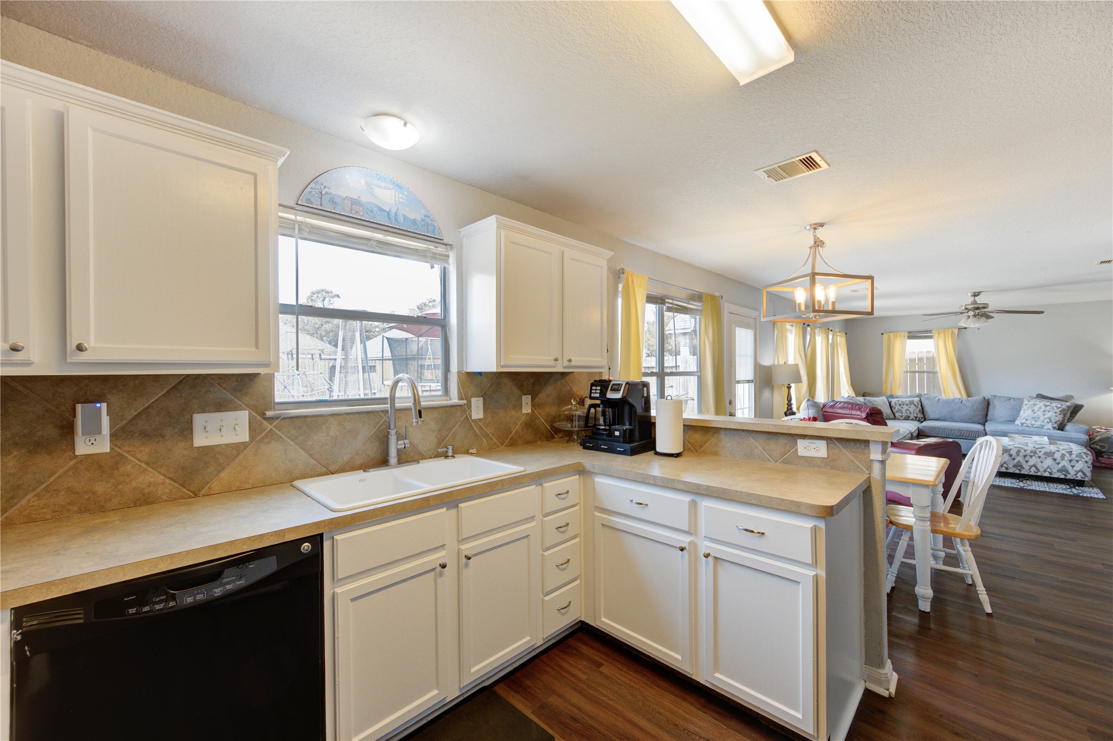 19103 Crystola Park Spring, TX 77373 - Photo 17 of 49 a kitchen with a sink dishwasher a stove and white cabinets with wooden floor