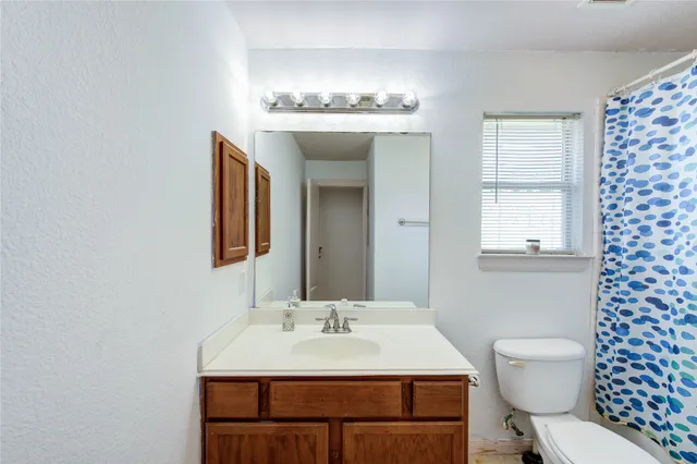 a bathroom with a sink vanity mirror and toilet