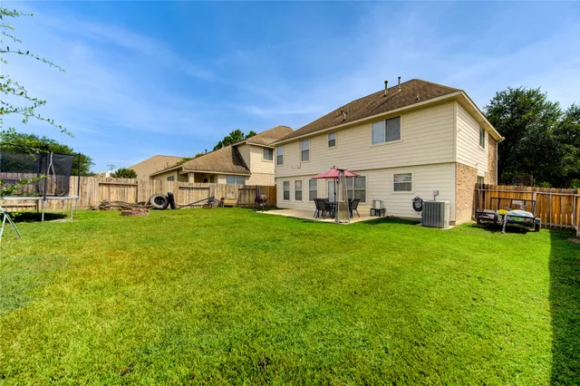 a view of a white house with a big yard and large trees