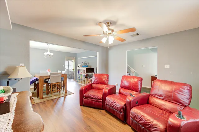 a living room with furniture a ceiling fan and a rug