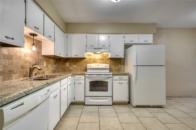 a kitchen with a stove top oven sink and cabinets