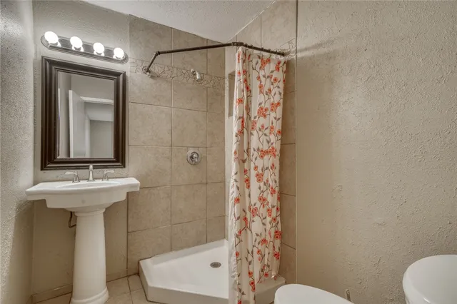 a bathroom with a shower a toilet and sink