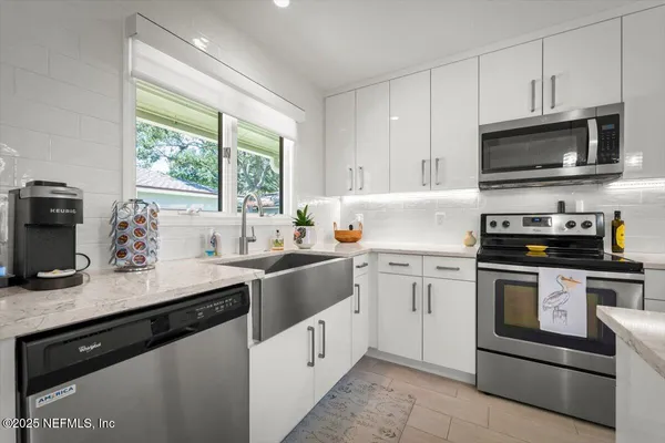 a kitchen with stainless steel appliances kitchen island granite countertop a stove a sink a dining table and chairs with wooden floor