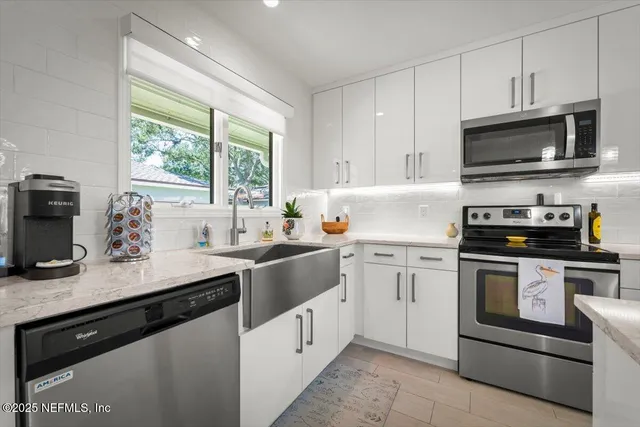 a kitchen with stainless steel appliances kitchen island granite countertop a stove a sink a dining table and chairs with wooden floor