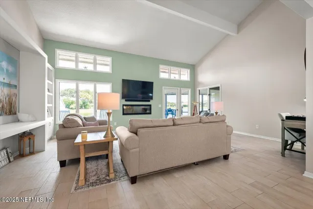 a living room with furniture a large window and a chandelier