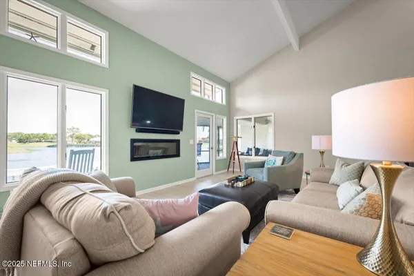 a living room with furniture a clock and a large window