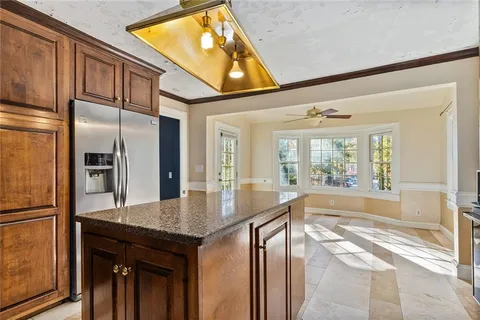a kitchen with granite countertop a refrigerator and a sink