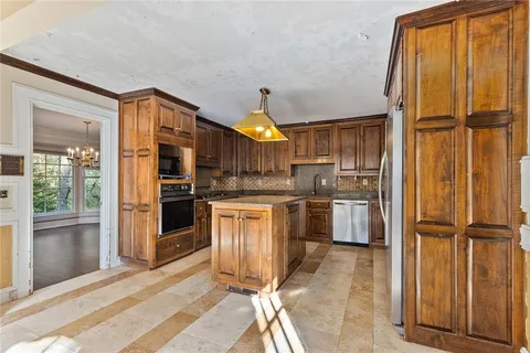 a kitchen with stainless steel appliances granite countertop a refrigerator and a sink