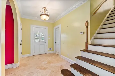 a view of a hallway with entryway and chandelier