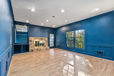 a view of an empty room with window and wooden floor
