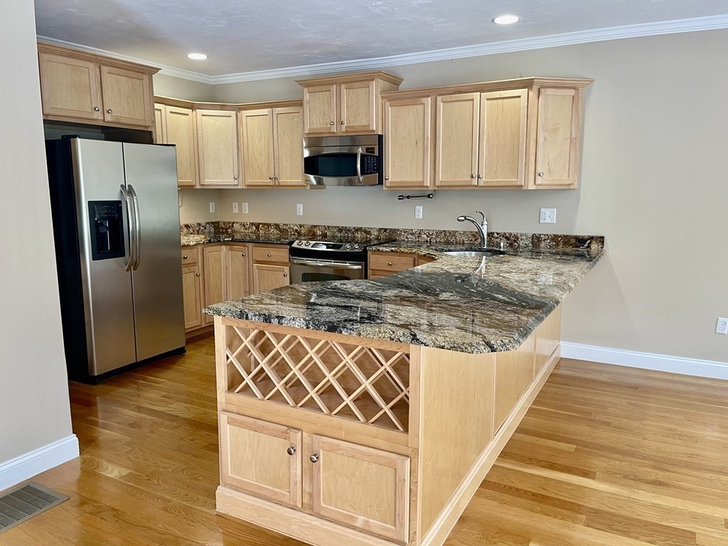 113 Dudley Road, Unit 113 Berlin, MA 01503 - Photo 5 of 17 a kitchen with stainless steel appliances granite countertop a stove a sink and a refrigerator