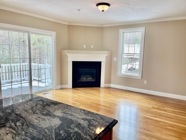 113 Dudley Road, Unit 113 Berlin, MA 01503 - Photo 8 of 17 a view of an empty room with wooden floor and a window
