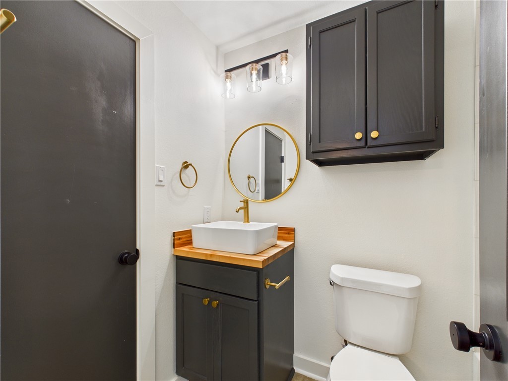 309 Mobile Avenue, Unit 5 Bryan, TX 77801 - Photo 15 of 17 a bathroom with a toilet sink and mirror