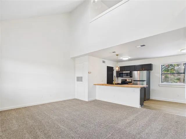 a large white kitchen with kitchen island a sink a stove and a refrigerator
