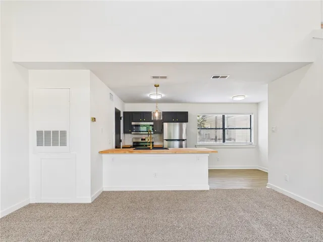 a view of a kitchen with kitchen island and stainless steel appliances