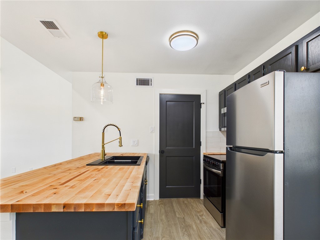 309 Mobile Avenue, Unit 5 Bryan, TX 77801 - Photo 7 of 17 a kitchen with stainless steel appliances granite countertop a refrigerator a sink and a stove