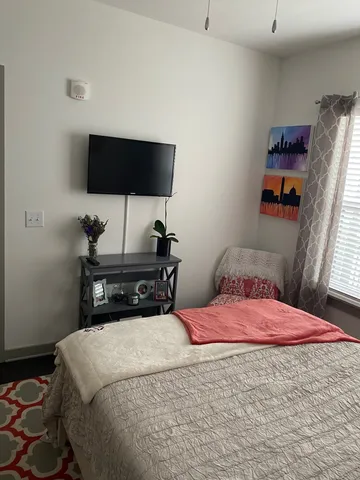 a bedroom with a bed and a flat screen tv