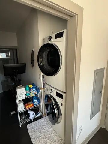 a utility room with dryer washer and a view of living room