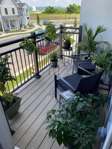 a view of a balcony with wooden floor outdoor seating and city view