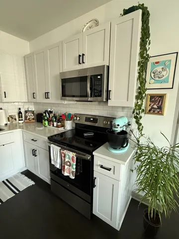 a kitchen with stainless steel appliances a stove a microwave and cabinets