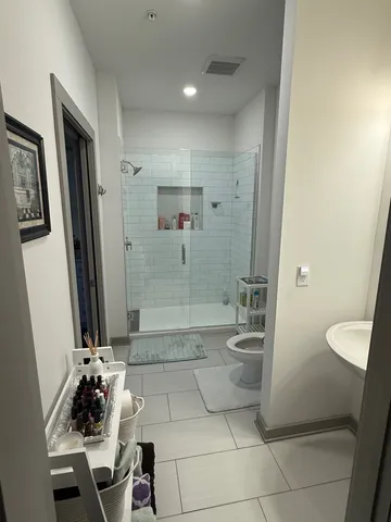 a bathroom with a granite countertop sink a toilet and a shower