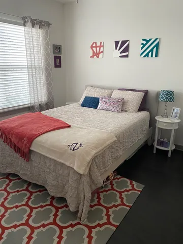 a bedroom with a bed and wooden floor