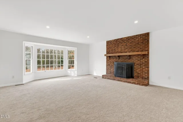 a view of empty room with wooden floor and ceiling fan