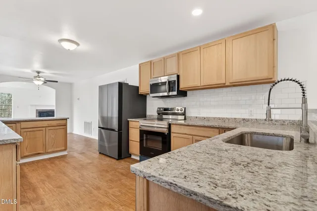 a view of a kitchen with a refrigerator and a ceiling fan