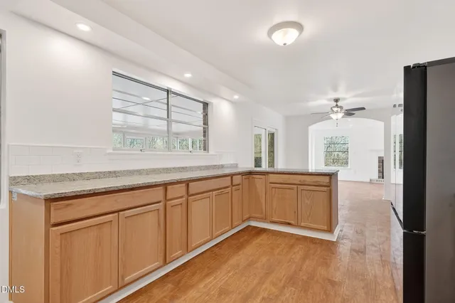 a view of an empty room with window and fire place