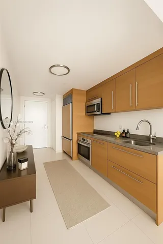 a large kitchen with stainless steel appliances granite countertop a stove a sink dishwasher and a microwave with wooden floor