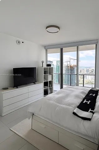 a bedroom with a bed and a flat screen tv