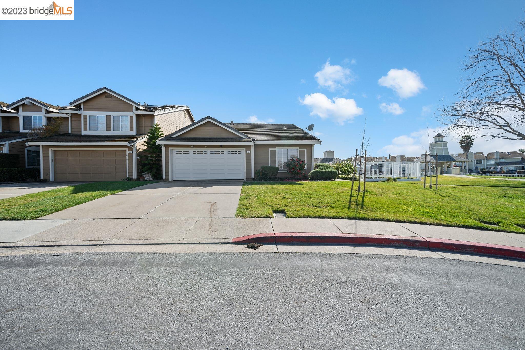 a view of a house with a yard and large trees