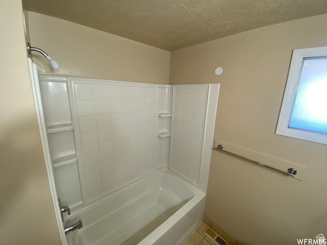 2182 West 5600th Street South Roy, UT 84067 - Photo 9 of 11 White bathtub and shower combination unit featuring integrated shelving