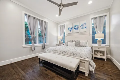 a spacious bedroom with a bed a dresser and next to a window