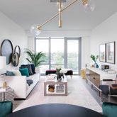 a living room with furniture and a large window with garden view