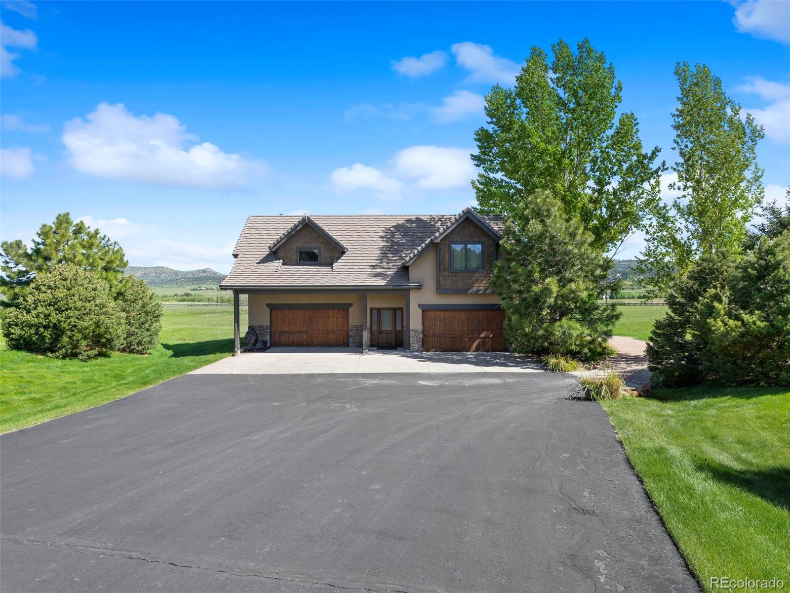 1395 Waverton Ranch Road Castle Rock, CO 80109 - Photo 35 of 40 a front view of a house with a yard and garage