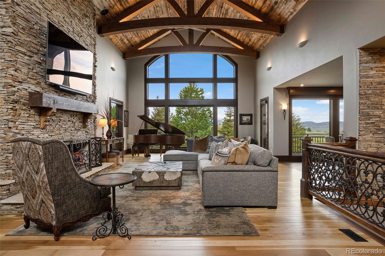1395 Waverton Ranch Road Castle Rock, CO 80109 - Photo 7 of 40 a living room with furniture and a floor to ceiling window