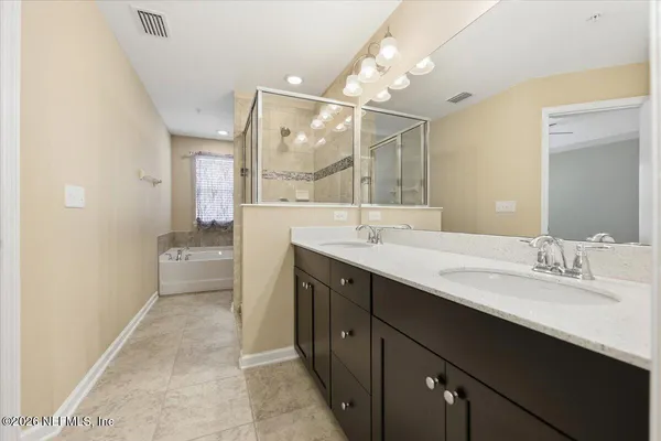 a bathroom with a double vanity sink mirror and shower