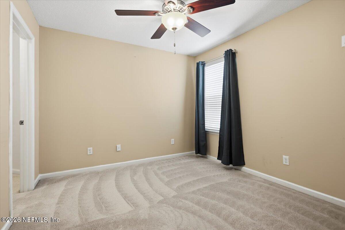148 Paradas Place St. Augustine, FL 32092 - Photo 16 of 24 an empty room with chandelier fan and windows
