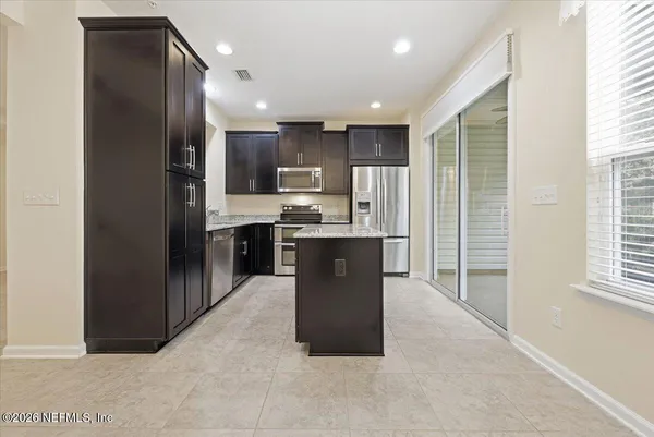 a kitchen with stainless steel appliances granite countertop a refrigerator a sink a stove and a refrigerator