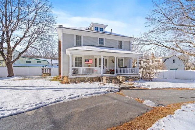 a front view of a house with a snow on the road