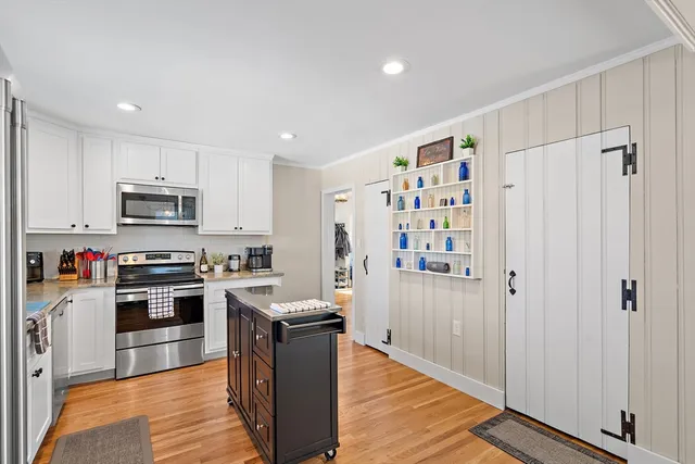 a kitchen with stainless steel appliances granite countertop a refrigerator stove a sink and a oven with wooden floor