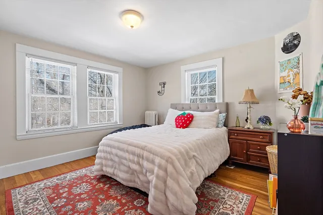 a bedroom with a bed a table and windows