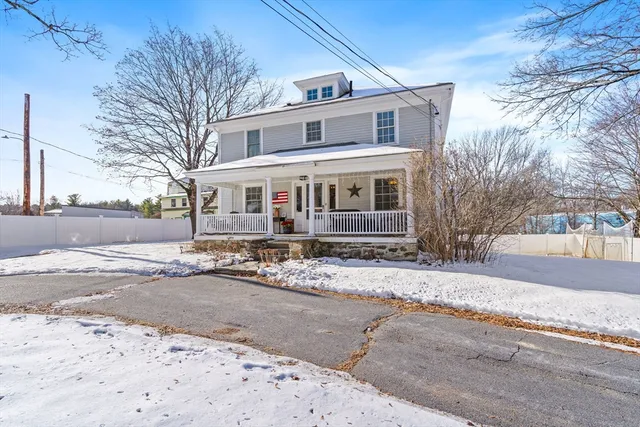 front view of a house with a snow on the road