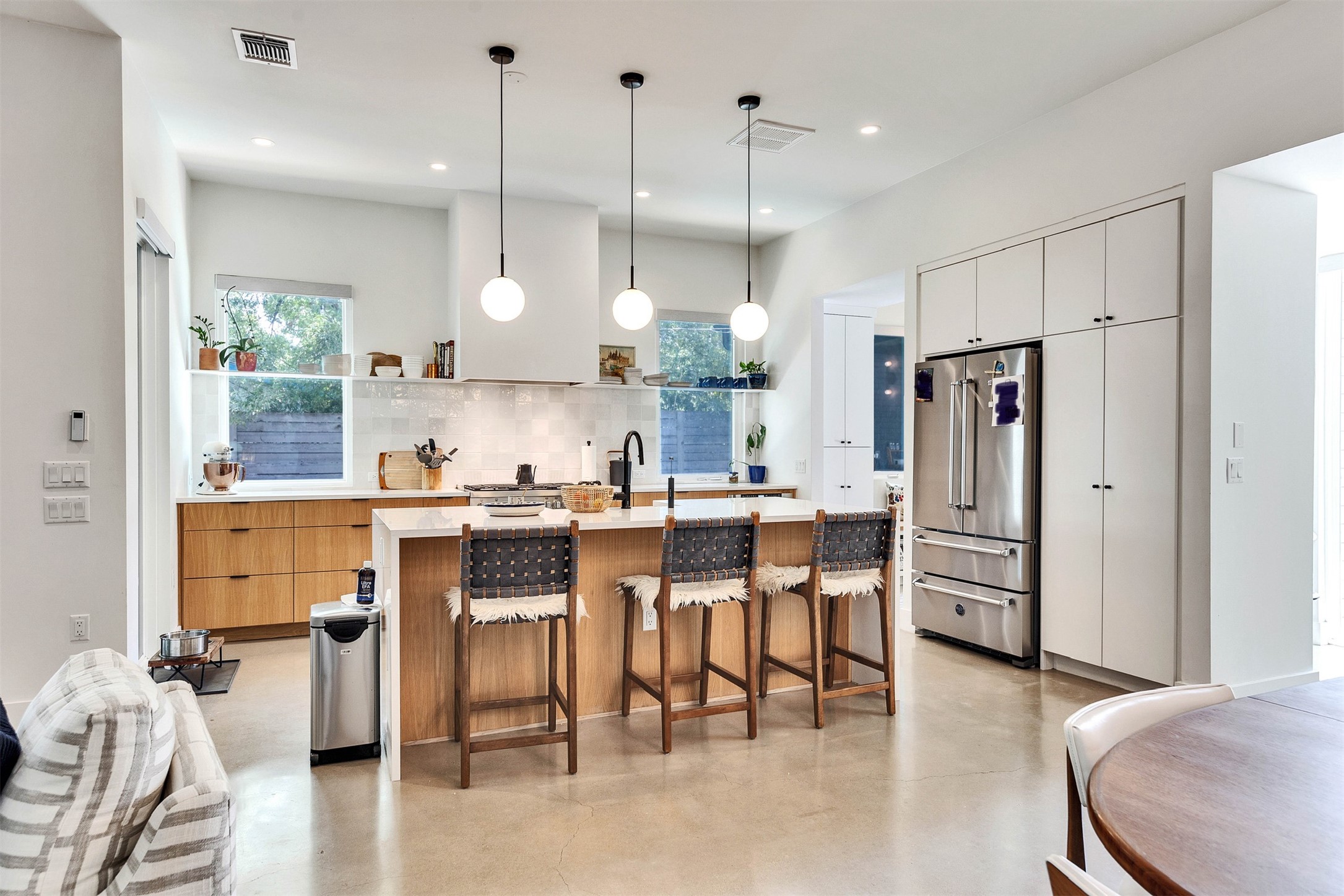 506 Powell Circle Austin, TX 78704 - Photo 16 of 39 a kitchen with stainless steel appliances kitchen island granite countertop a table chairs and a refrigerator
