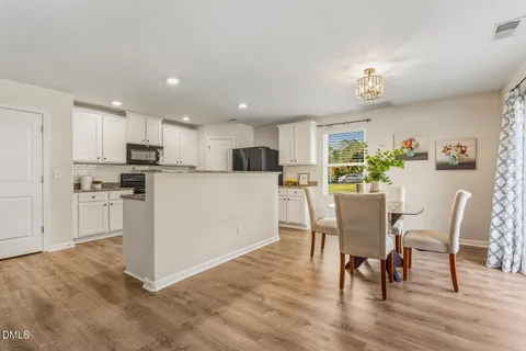 a kitchen with granite countertop a refrigerator a sink a stove a microwave a counter top space and cabinets