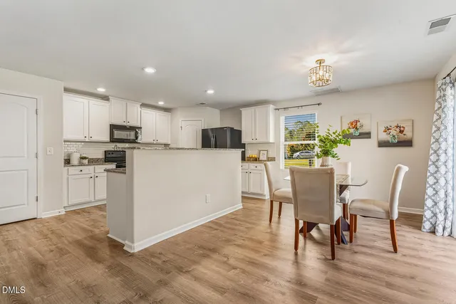 a kitchen with granite countertop a refrigerator a sink a stove a microwave a counter top space and cabinets