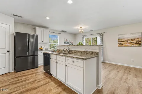 a kitchen with granite countertop white cabinets and a stove a oven with white countertops