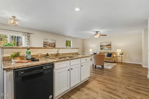 a kitchen with stainless steel appliances granite countertop a stove a sink and white cabinets
